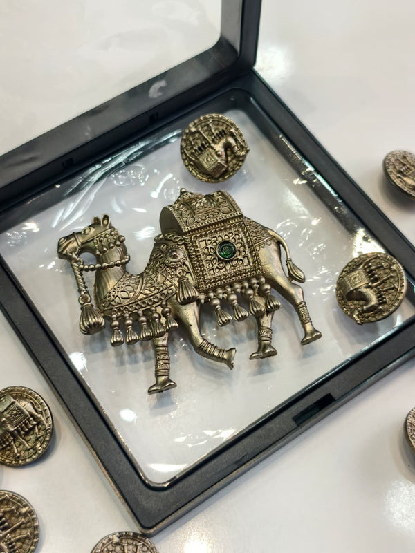 Decorative metal brooch set featuring a camel-shaped centerpiece and matching round buttons.