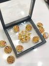 A gold-tone decorative brooch set with matching buttons, designed in a traditional ornamental style.