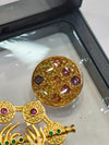 A gold-tone decorative brooch set with matching buttons, designed in a traditional ornamental style.