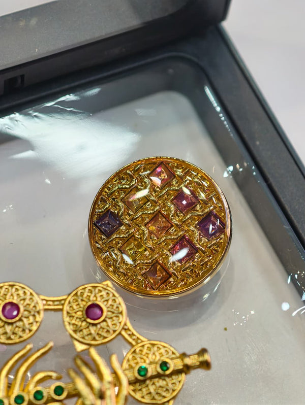 A gold-tone decorative brooch set with matching buttons, designed in a traditional ornamental style.