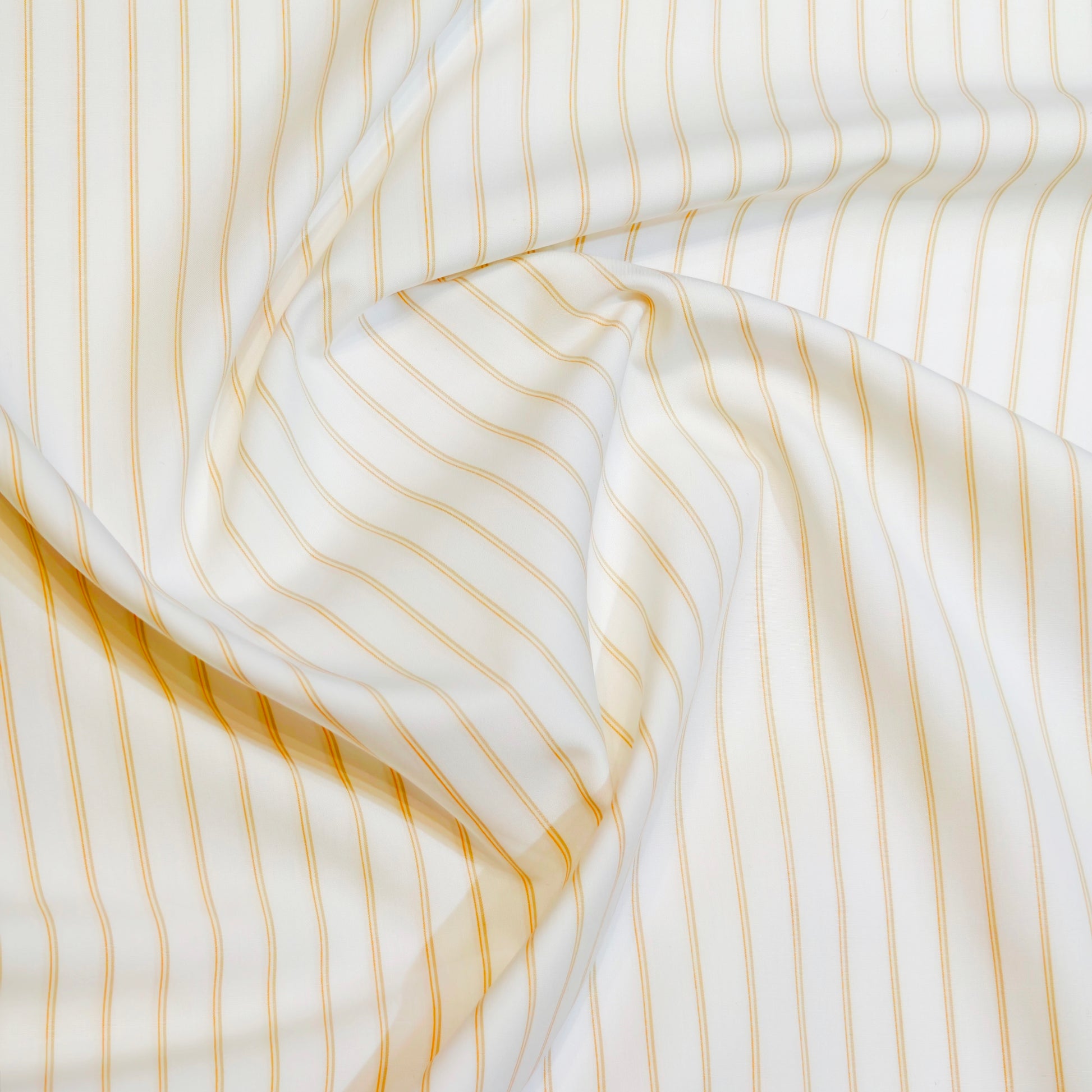 Close-up of white fabric with thin yellow stripes