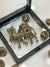 Decorative metal brooch set featuring a camel-shaped centerpiece and matching round buttons.